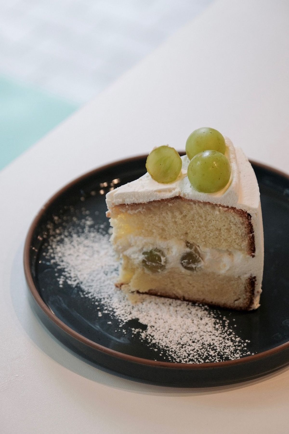 White grape chiffon cake topped with grapes and cream.